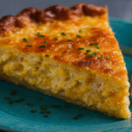 Cheddar corn pie in ceramic dish with golden crust and melted cheese