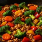 Ground chicken stir fry in wok with colorful vegetables and sauce